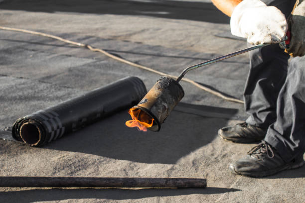 roll roofing installation with propane blowtorch during construction works