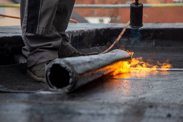 roofer during waterproofing work with bitumen membranes